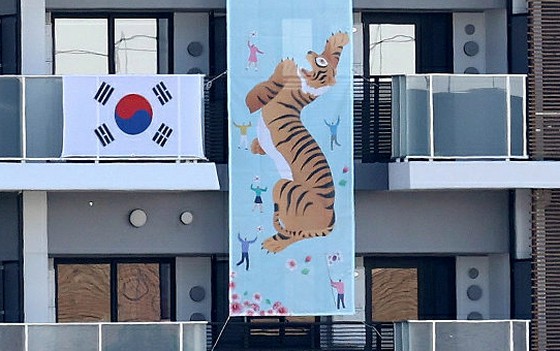 <W commentary> Đội tuyển Hàn Quốc vừa dựng biểu ngữ hình con hổ ở Làng Olympic Tokyo = "Khó khăn so với Hỗ trợ"