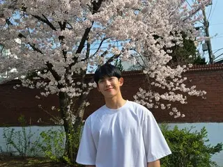Nam diễn viên Jung HaeIn mỉm cười với phông nền là hoa anh đào... “Mong các bạn có một ngày cuối tuần vui vẻ”
