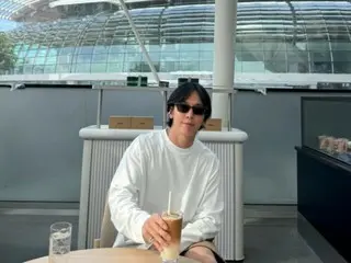 Jung Yong Hwa của CNBLUE thưởng thức một ly latte đá với Marina Bay Sands làm nền