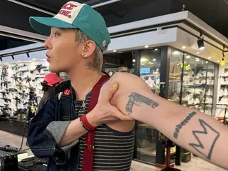 G-DRAGON (BIGBANG) ghé thăm một cửa hàng súng và khoe hình xăm súng trên cánh tay